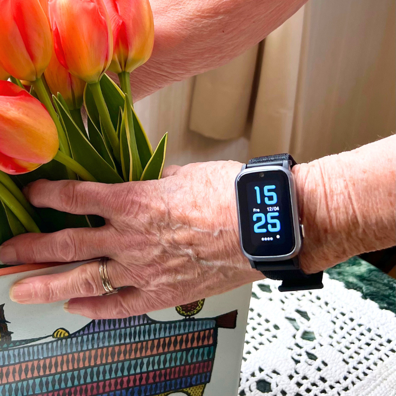 Ældre kvinde med Sensorem tryghedsalarm-ur med automatisk faldalarm om håndleddet